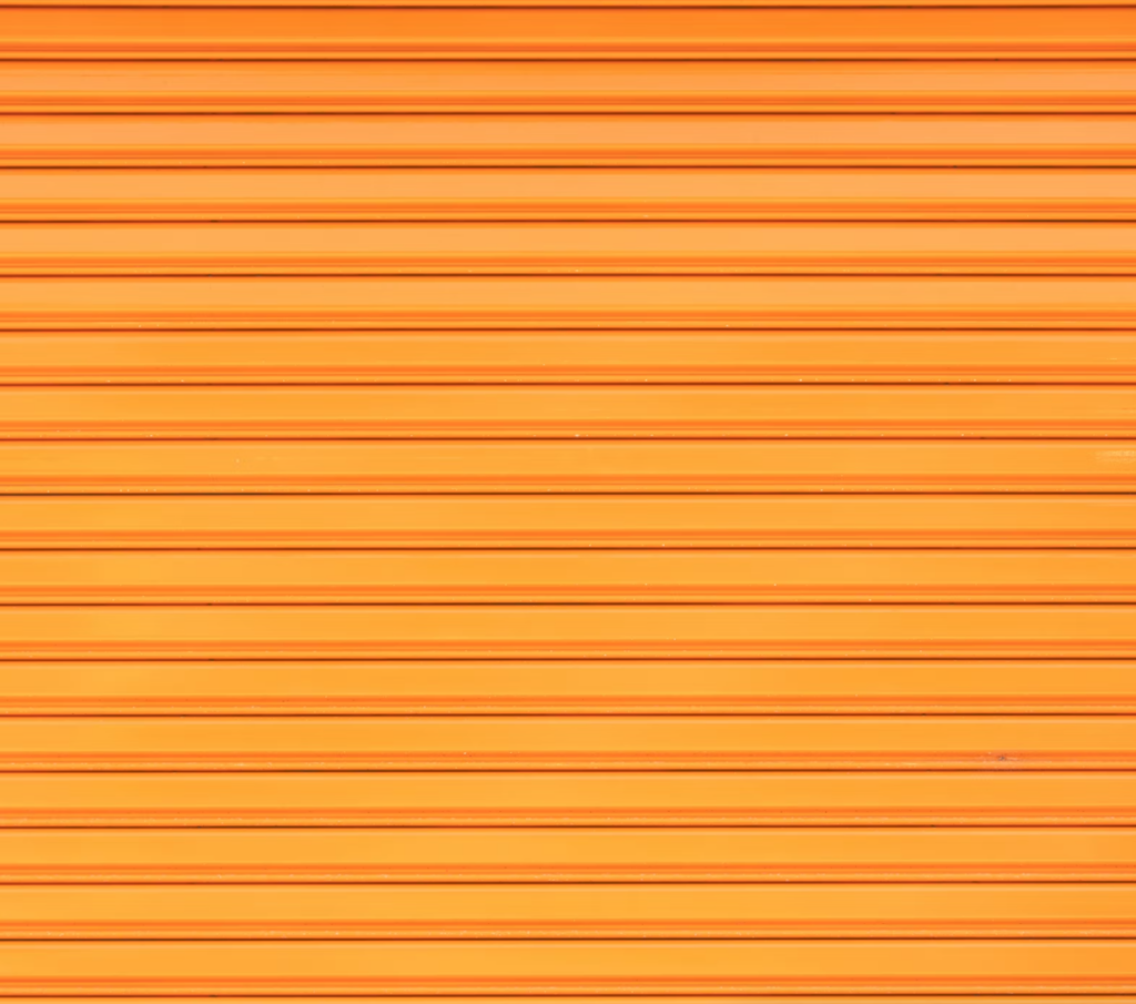 a close up of orange metal garage door