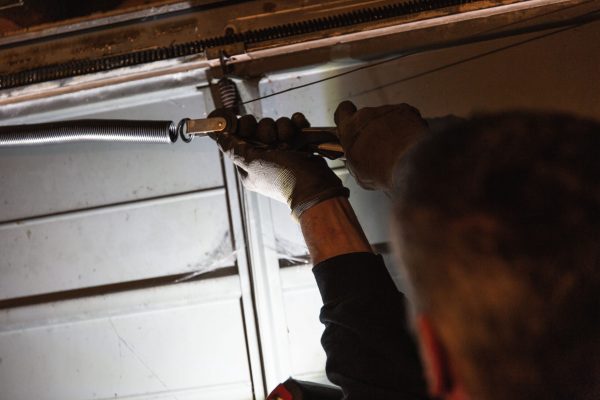 JB Garage Doors employee repairing old garage door