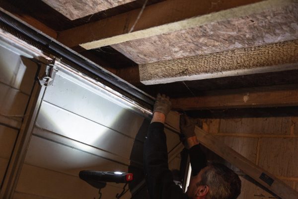 JB Garage Doors employee repairing garage door