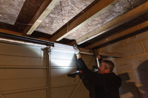 JB Garage Doors employee repairing old garage door