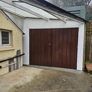 Steel side hinged garage doors with white frame.
