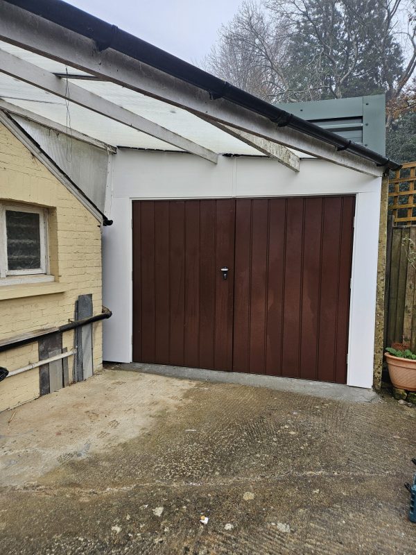 Steel side hinged garage doors with white frame.