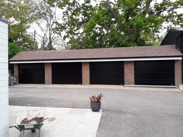 Four ribbed black Hormann garage doors.